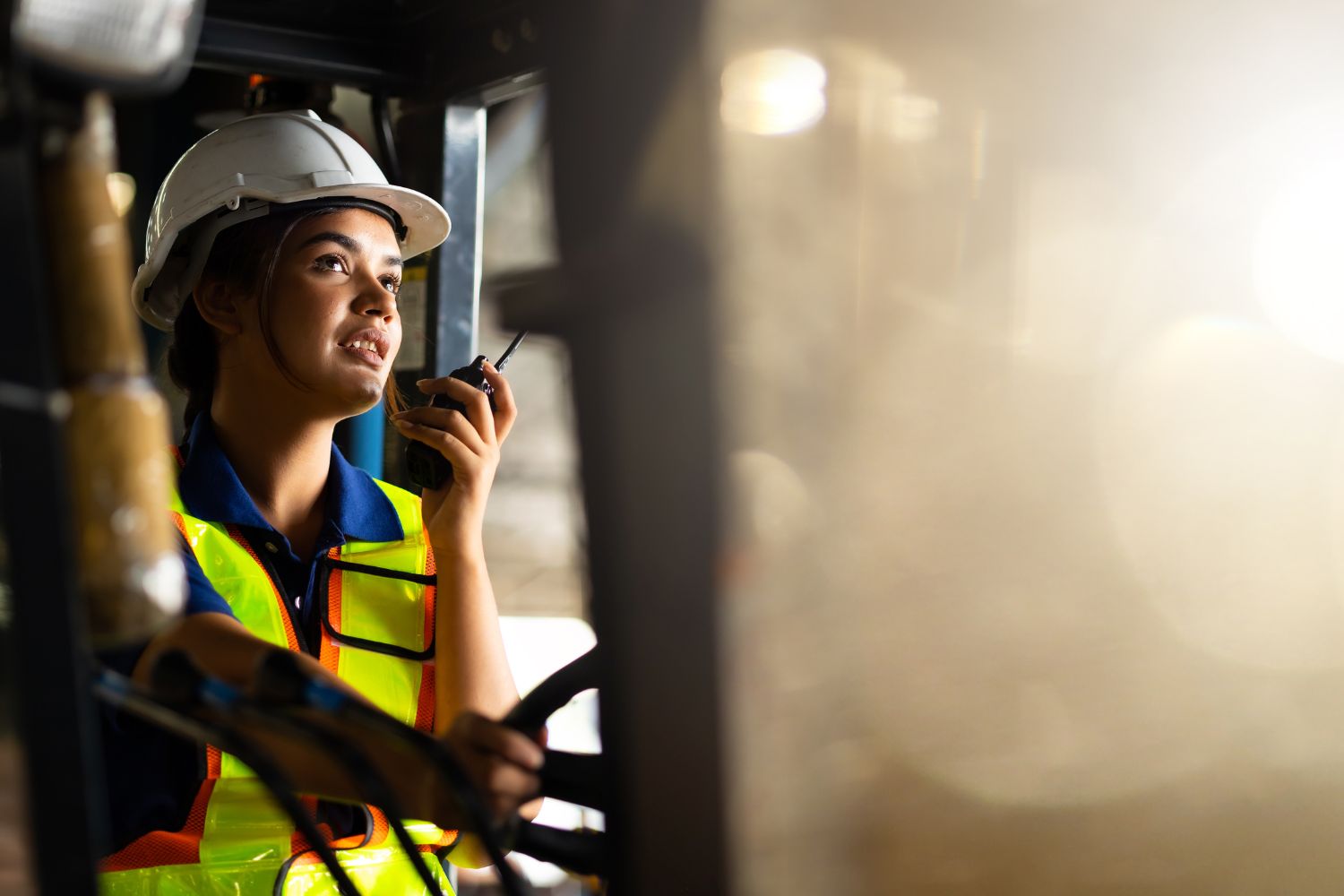 A woman driving a small equipment vehicle talking on a radio