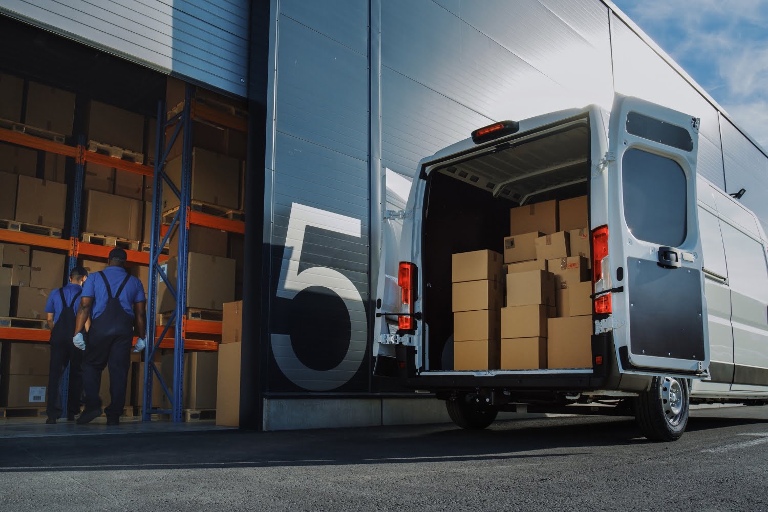 Door to door transport example shown by a cargo transport van stacked with boxes outside a warehouse for home delivery