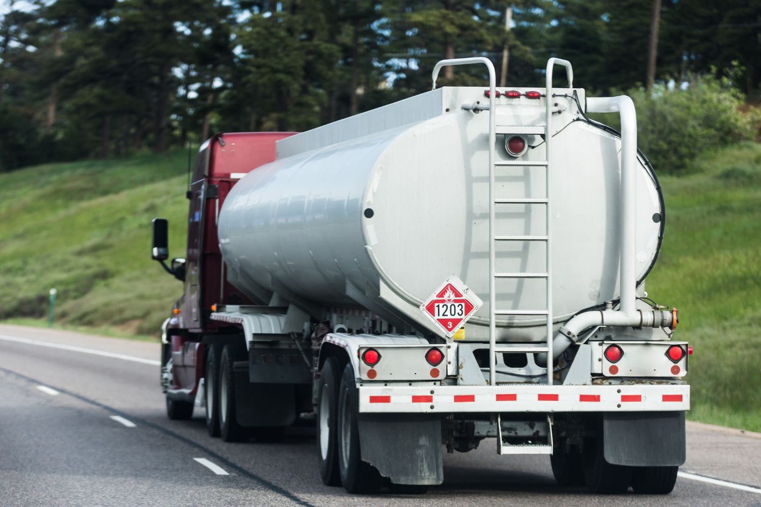  Image of a Tanker Truck from the back while its driving down a road